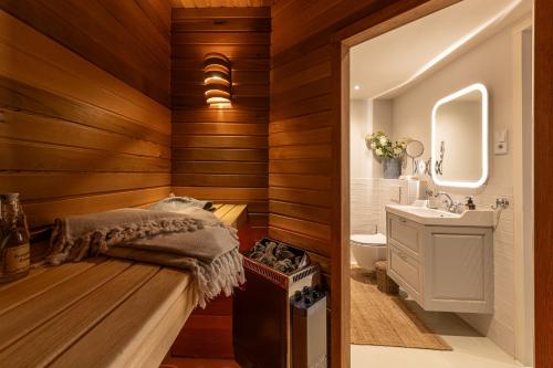 a bathroom with wooden walls and a sink and a toilet at Logement Welgelegen - Charming private stay with sauna near Nijmegen in Millingen aan de Rijn