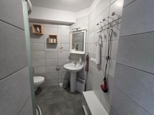 a white bathroom with a sink and a toilet at Dom Gościnny KOJA in Kołobrzeg