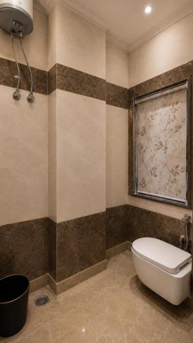 a bathroom with a toilet and a window at Wama Rooms in New Delhi