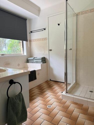 a bathroom with a shower and a sink at Valley View House in Gympie