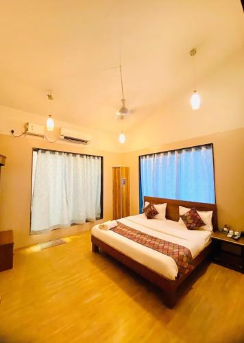 a bedroom with a bed and a large window at Amrapali Villa at Raghunandan Resort in Nashik