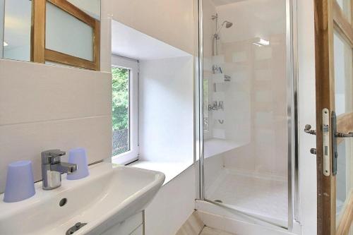 a white bathroom with a shower and a sink at Cottage - Sleeps 4 with Log Burner & Pet Friendly in Kérien