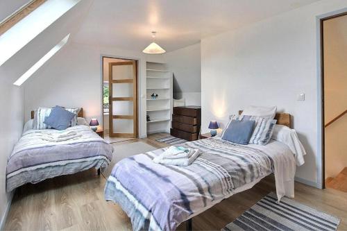 a bedroom with two beds and a closet at Cottage - Sleeps 4 with Log Burner & Pet Friendly in Kérien