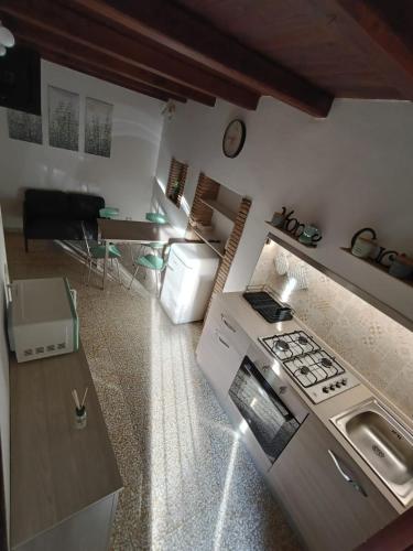 a kitchen with a stove and a living room at La Loggetta in Bagnaia