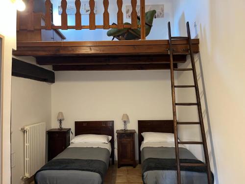 two bunk beds in a room with a ladder at La Loggetta in Bagnaia