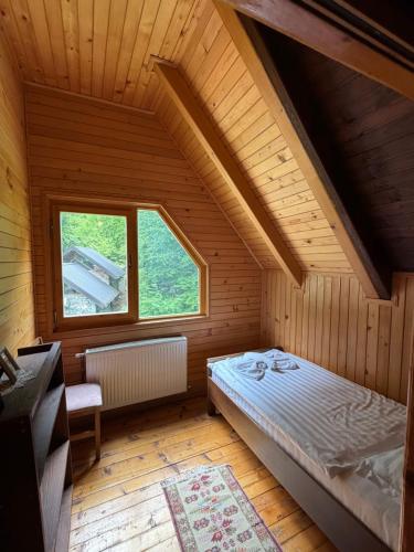 ein Schlafzimmer mit einem Bett in einem Zimmer mit Fenster in der Unterkunft Hostel & Camping Rilindja in Valbonë