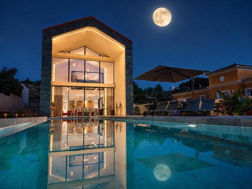 a house with a pool at night with the moon at Luxury Villa Galaxy Beach 12min walk 15m pool in Calpe