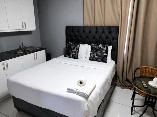 a bedroom with a large bed with a black headboard at Springforth Guesthouse in De Grendel