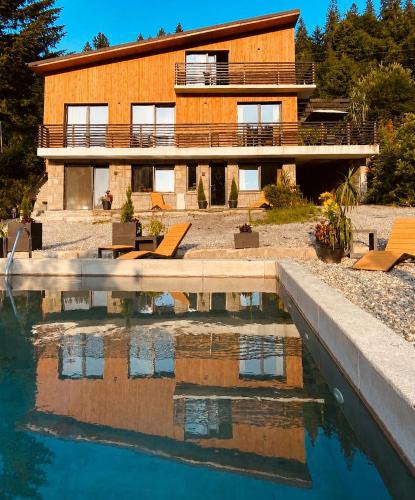 a house with a pool in front of a building at Dom i Las in Brenna
