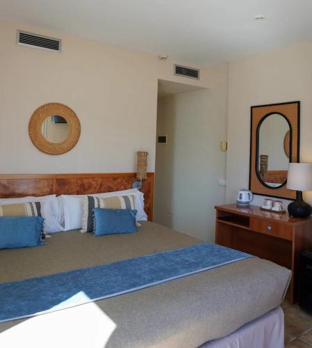 a bedroom with a bed and a dresser and a mirror at La Muntanya in Llafranc