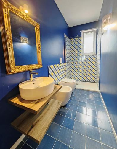 a blue bathroom with a sink and two toilets at Minnelea Blue Retreat in Acciaroli