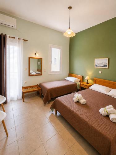 a hotel room with two beds and a mirror at Zannikos Rooms in Ermoupoli