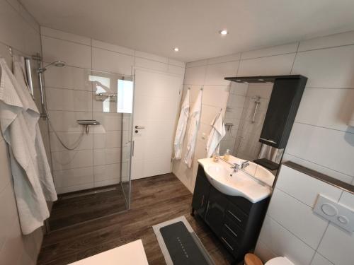 a bathroom with a sink and a shower at Haus am Deich in Norden