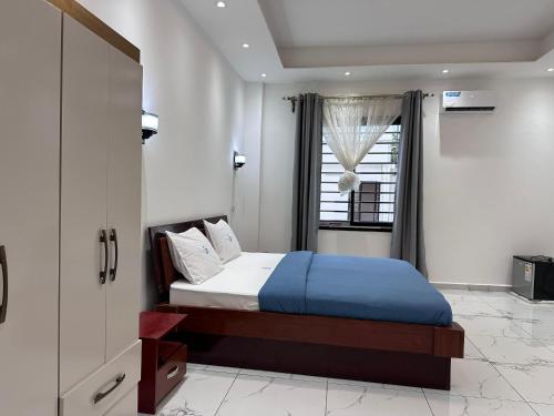 ein Schlafzimmer mit einem Bett und einem Fenster in der Unterkunft Charnel hosting in Kribi