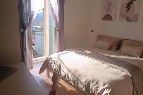 a bedroom with a bed and a window with a balcony at Torre del Borgo - Centro Storico di Accettura in Accettura