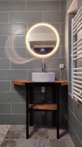 a bathroom with a sink and a mirror at Logement cosy proche Cluny in Buffières