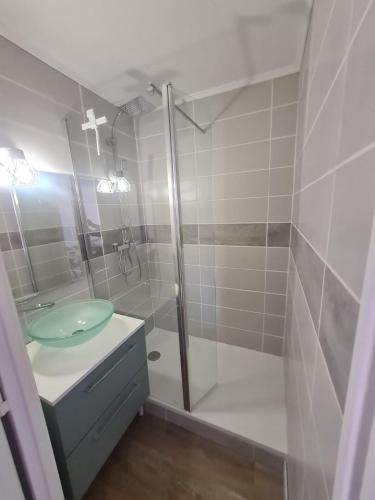 a bathroom with a glass shower with a sink at Le cocon Sétois - T2 et garage privé in Sète
