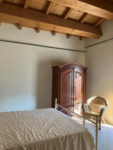 a bedroom with a bed and a wooden cabinet at Appartamento Villa Reale in Castel SantʼAngelo