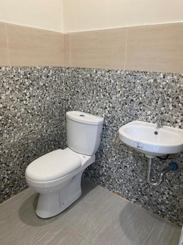 a bathroom with a toilet and a sink at ZK Loft Staycation Gensan in General Santos
