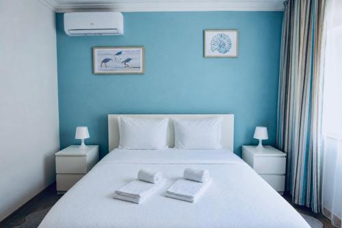 a blue bedroom with a bed with two towels on it at Residencial Princesa do Ave in Vila do Conde
