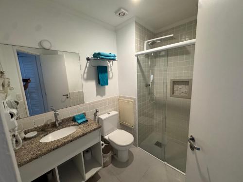 a bathroom with a toilet and a sink and a shower at Flat lindo a 120 metros da praia de Riviera de São Lourenço até 4 pessoas in Bertioga