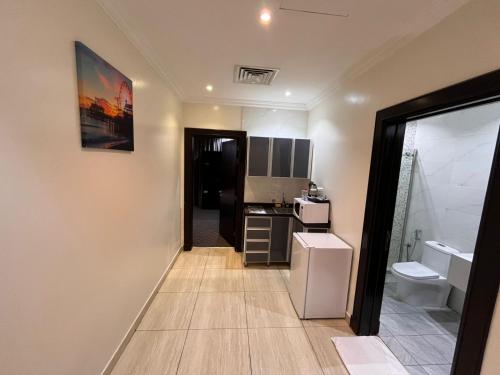 a small kitchen with a sink and a refrigerator at Art Suite in Riyadh