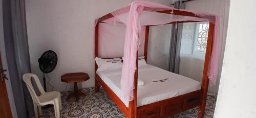 a bedroom with a bunk bed with a pink canopy at Ngalula Half London Resort in Dzitsuhe