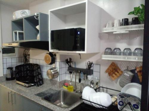 a kitchen with a sink and a counter top at Unit 207C Amani Grand Resort & Residences in Pusok