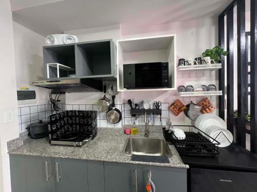a kitchen with a sink and a counter top at Unit 207C Amani Grand Resort & Residences in Pusok