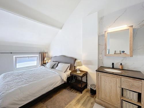 a bedroom with a bed and a sink and a mirror at Charmante maison in Namur