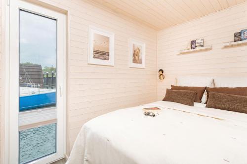 a bedroom with a bed and a large window at Hausboot Sophie in Stralsund in Stralsund