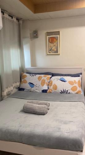 a bedroom with a large bed with two pillows at ZK Loft Staycation Gensan in General Santos