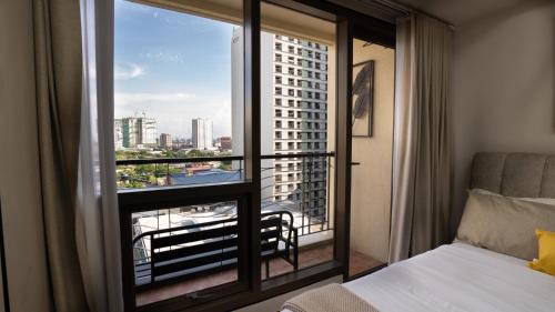 a bedroom with a bed and a window with a view at The Mosaic Tower Luxury Boutique Studio,Pool and Gym Fast Wifi in Manila