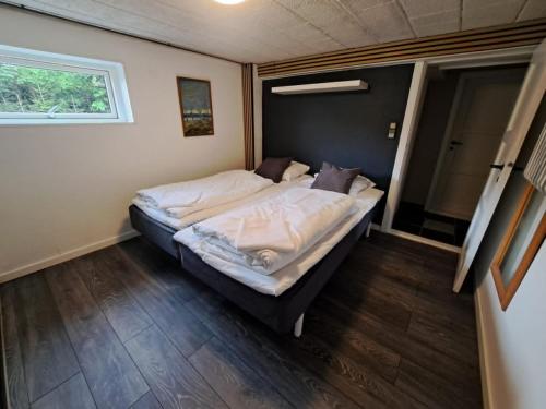 a bedroom with a large bed with white sheets at Byhus i Glyngøre in Glyngøre