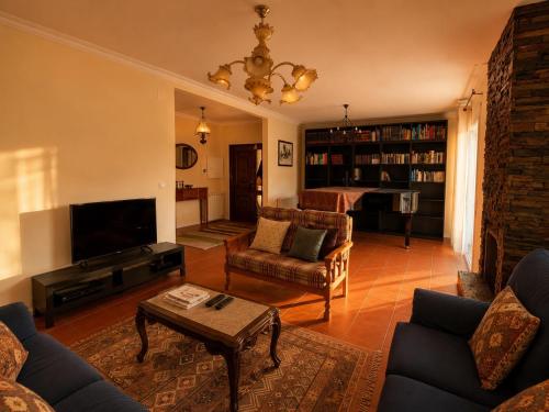 a living room with a couch and a tv and a table at Spacious Villa near Porto - BBQ and Private Parking in Vila Nova de Gaia