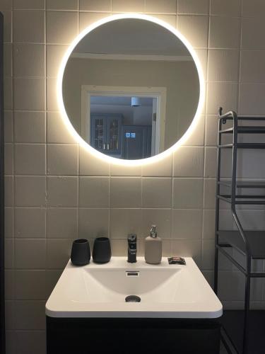 a bathroom with a white sink with a round mirror at Bitihorn in Beitostøl