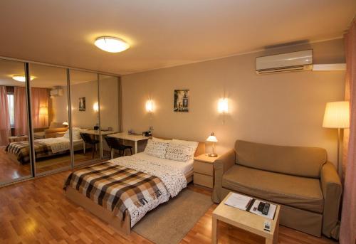 1 dormitorio con cama, sofá y mesa en TVST Apartments Belorusskaya, en Moscú