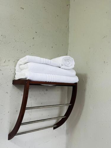 a shelf with white towels on a wall at Rest Easy Guest House Pty Ltd Unit 5 in Boksburg