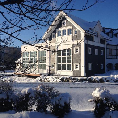 a large house with snow on the ground at Lahntalhotel Feudingen in Bad Laasphe