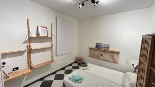 a room with a bed and a black and white checkered floor at Patios de la Carmela in Isla Cristina