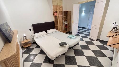 a bedroom with a bed and a checkered floor at Patios de la Carmela in Isla Cristina