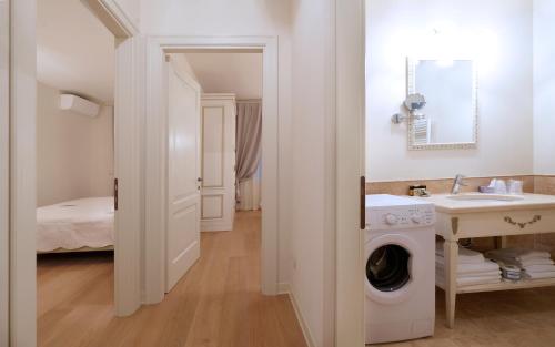 een badkamer met een wasmachine en een wastafel bij Garda Apartments San Vigilio Golf in Pozzolengo
