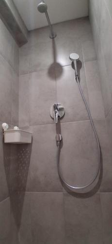 a shower with a hose in a bathroom at Mili's B&B Guest House in Gabrovo