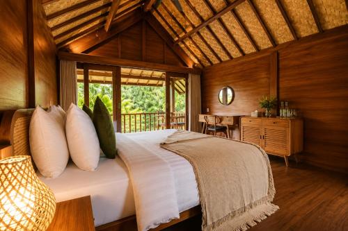 a bedroom with a large bed in a room at The Payung House - Romantic Riverside Villa in Bebandem