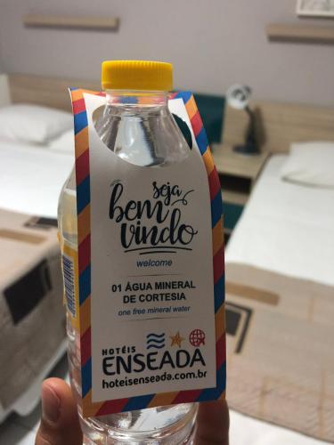 a hand holding a bottle of evian milk at Hotel Enseada Boa Viagem in Recife