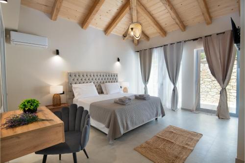 a bedroom with a bed and a table and chairs at TS Luxury villa in Velianitátika