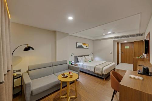a hotel room with a couch and a bed at Click Collection Aster, Raja Park - Jaipur in Jaipur