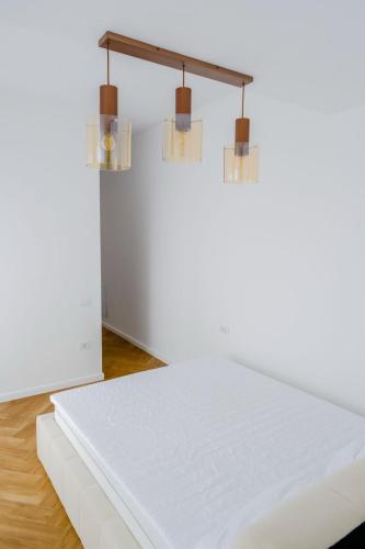 a white table in a room with three lights at Ayan Băile Felix Apartament in Baile Unu Mai