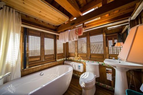a bathroom with a bath tub and a sink at Imperial Guard Boutique Hotel御前侍卫艺术精品酒店 in Yi