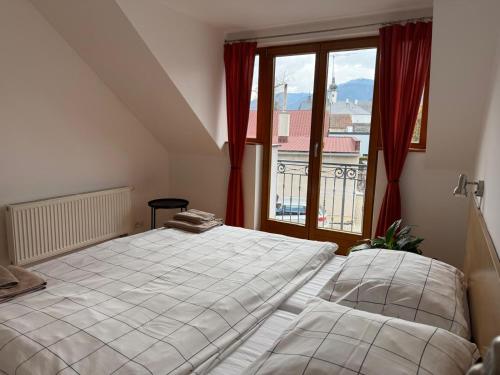 a bedroom with a bed and a large window at Privát Kompišovci in Liptovský Ján